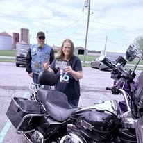 Community participant posing beside a motorcycle